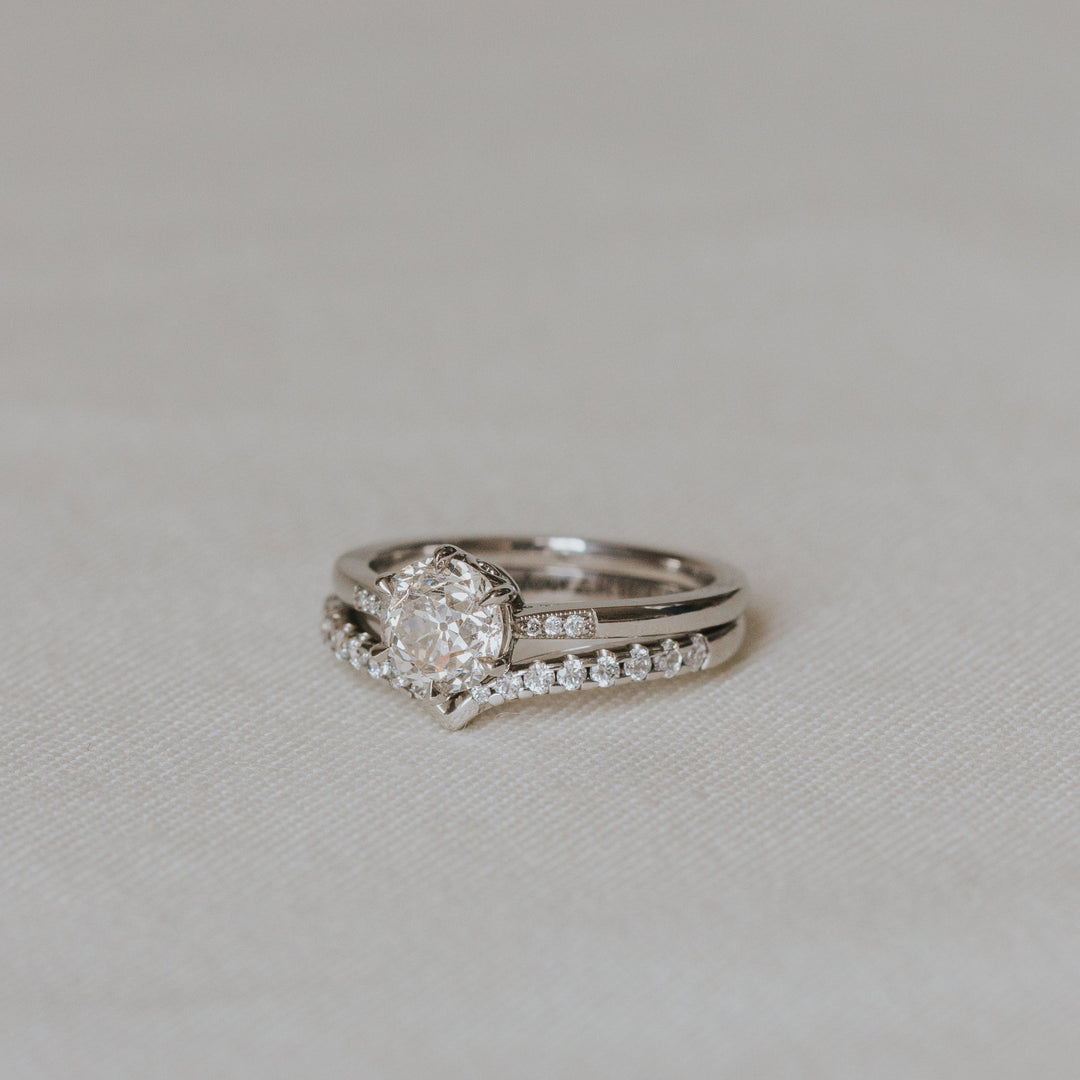 Platinum wedding ring set with a diamonds on a light gray background