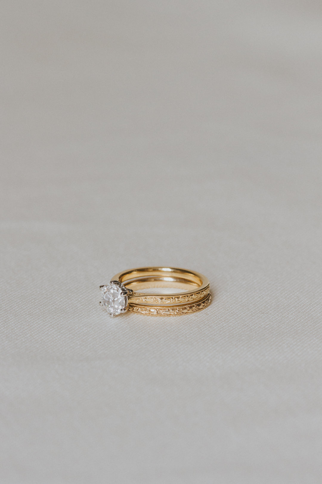 Gold ring with a diamond on a light gray background